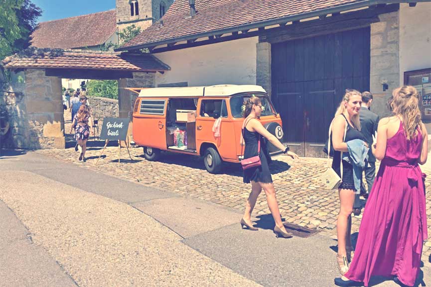 belles femmes en jupe devant combi VW loué dans vieille ville avec rue pavée