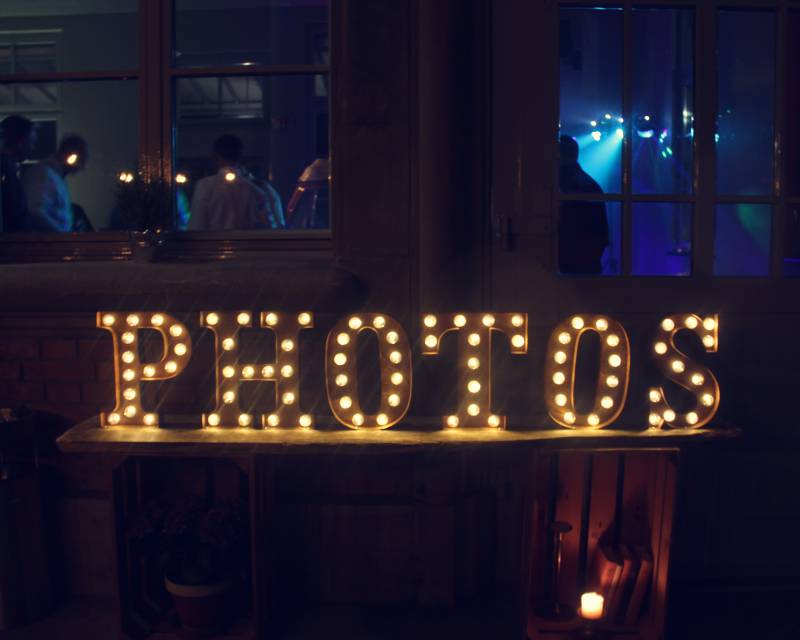 Leuchtbuchstaben vom Photobus vor Club mit tanzenden Gästen