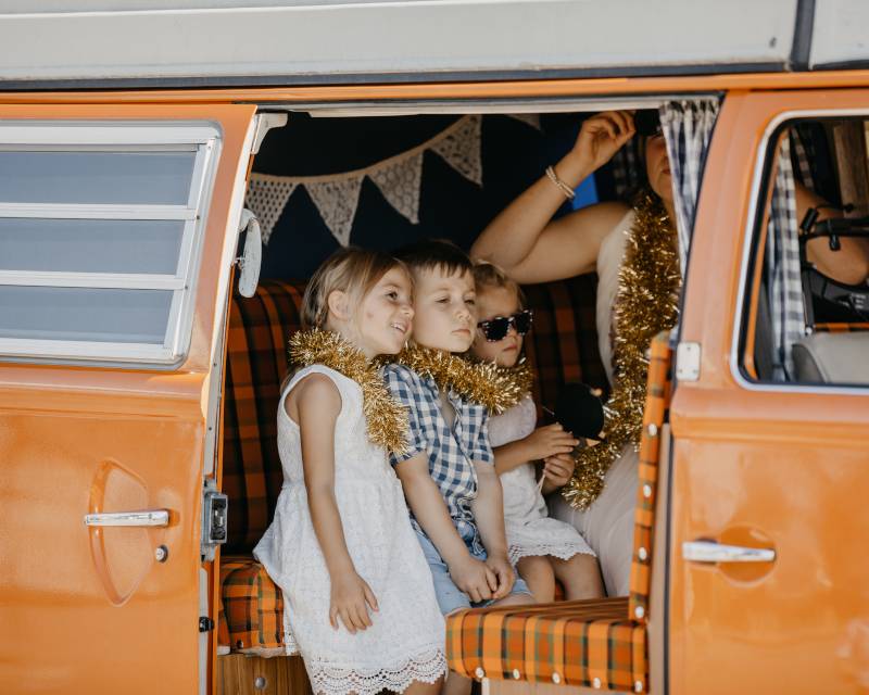 enfants posent dans photobox dans vieux combi VW