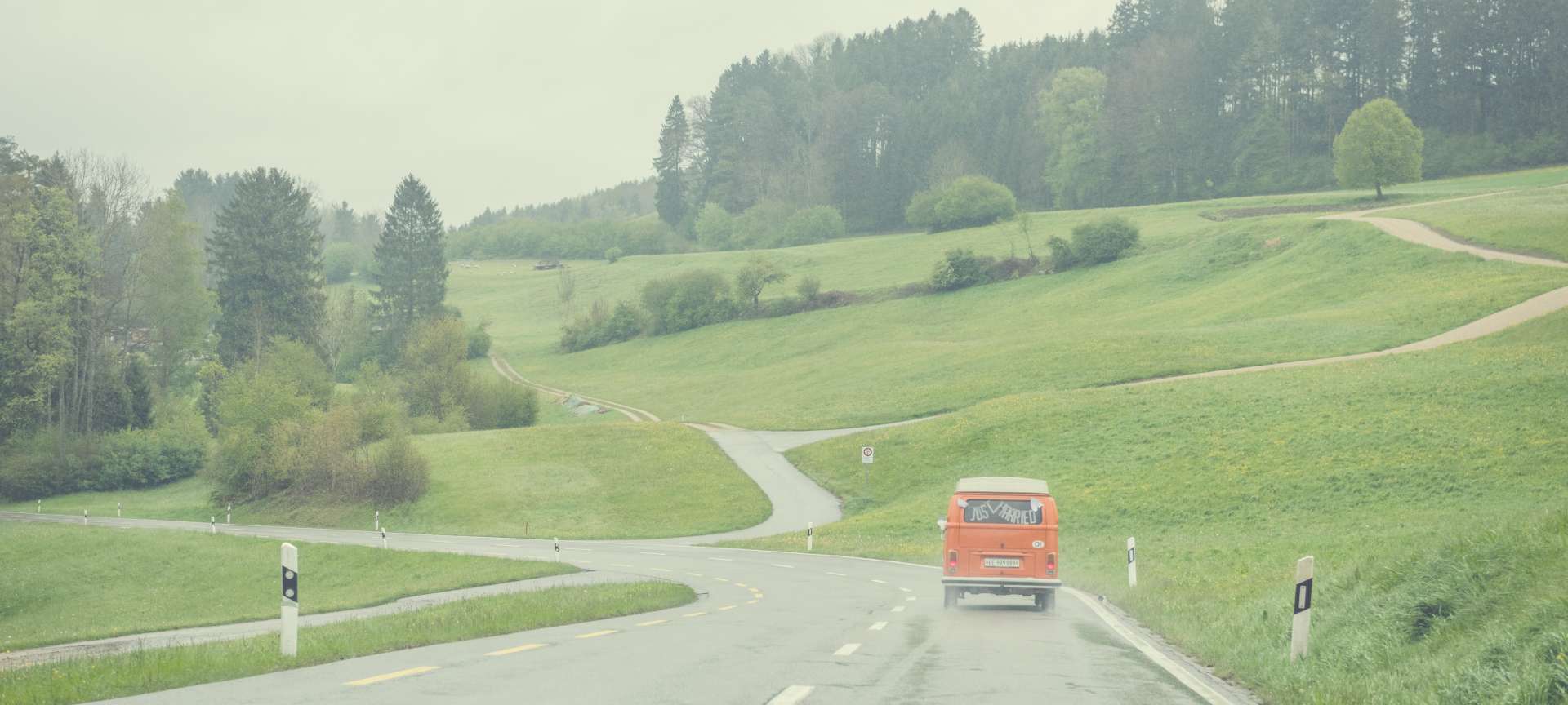 Hippie-Bus mit Just Maried Schriftzug von hinten auf Landstrasse im Kanton Zürich