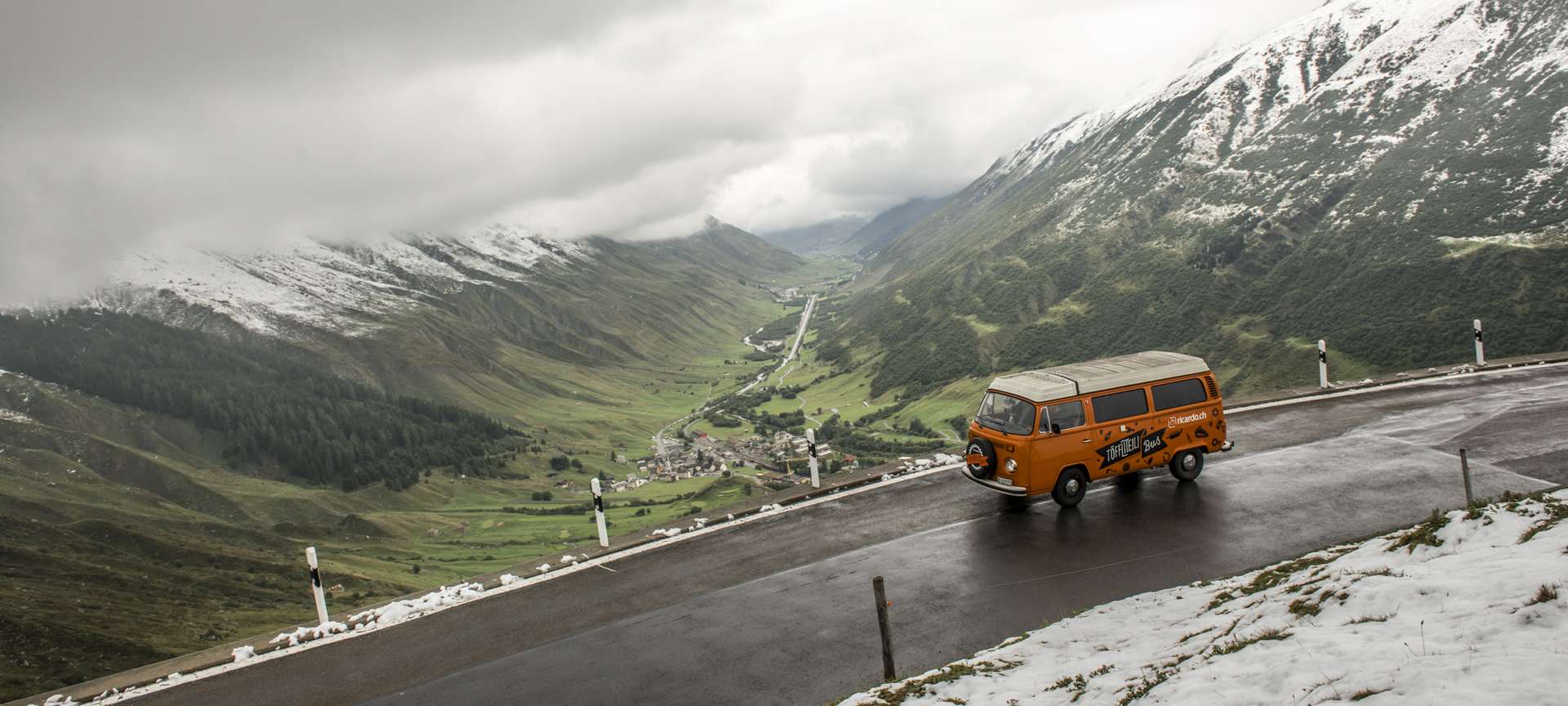 Rue suisse avec bus VW de location (publicité)